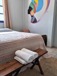 a bedroom with a bed with two towels on a bench at Soul Hostel Natal in Natal