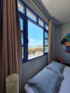 a bedroom with a bed and a large window at Soul Hostel Natal in Natal