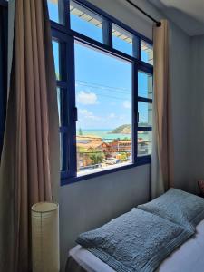 a bedroom with a window with a view of the ocean at Soul Hostel Natal in Natal