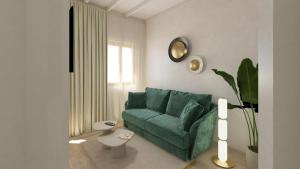 a living room with a green couch and a window at LLONGA'S Ciutadella in Ciutadella