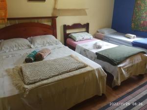 a room with three beds in a room at O Brejo Encantado Hospedagem e Pousada in Embu