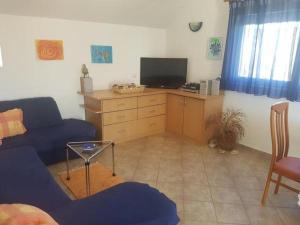 een woonkamer met een blauwe bank en een tv bij Apartment in Slatine with sea view, terrace, air conditioning, WiFi 5147-1 in Slatine