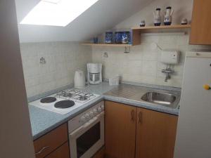 a small kitchen with a stove and a sink at Apartment in Slatine with sea view, terrace, air conditioning, WiFi 5147-1 in Slatine