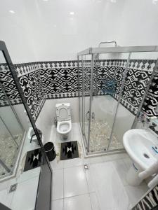 a bathroom with a toilet and a sink at Jannat Minor Boutique Hotel in Urganch