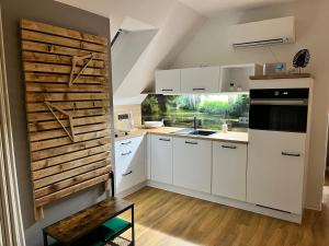 a kitchen with white cabinets and a wooden wall at Zur kleinen Glocke in Burg