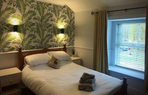 a bedroom with a bed with a leafy wallpaper at Red Lion Coaching Inn in Redbourne