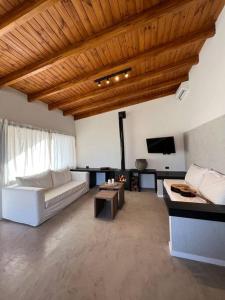 ein Wohnzimmer mit einem weißen Sofa und einem TV in der Unterkunft Casa de la Libélula con pileta in Alta Gracia