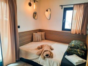 a teddy bear laying on a bed in a bedroom at Zawobaja in Zawoja