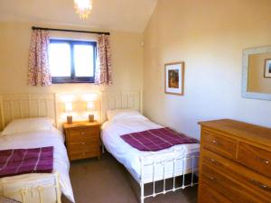 1 dormitorio con 2 camas y ventana en Smallthorns Barn en Market Harborough