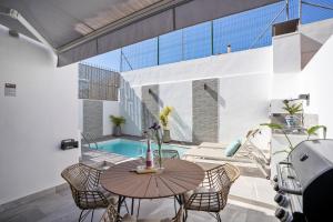 a patio with a table and chairs and a pool at Casa Los Limones in Fuengirola