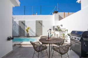 a patio with a table and chairs and a pool at Casa Los Limones in Fuengirola