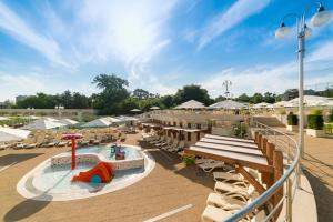 um resort com piscina, mesas e cadeiras em Lotus Therm Spa&Luxury Resort em Baile Felix