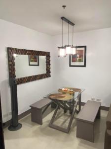 a dining room with a table and a mirror at CDO UPTOWN CONDOMINIUM in Cagayan de Oro