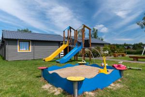 a playground with a slide in a yard at Mielenko Domki Wakacyjny Raj in Mielenko