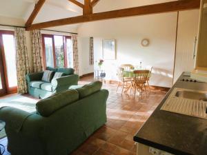 a living room with two green couches and a table at Smallthorns Barn in Market Harborough