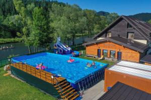 a group of people are in a swimming pool at Goralské drevenice Pieniny in Červený Kláštor