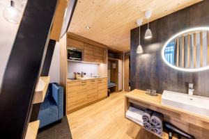 a bathroom with a sink and a mirror at BOLLWERK Lifestyle Hotel, automatisiertes Hotel mit Self Check In in Immenstadt im Allgäu