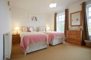 a white bedroom with two beds and a mirror at Spacious Stylish House,R/way Museum,Parking,Garden in York