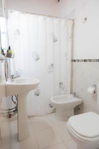 a white bathroom with a toilet and a sink at Mamma, Esquel. in Esquel