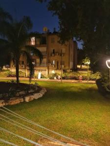 a large building with a palm tree in a park at Lovely Apt Close to Beach in Nahariyya