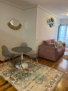 uma sala de estar com uma mesa e um sofá em Apartamentos El Escudo Centro em Ribadesella