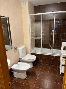 a bathroom with two toilets and a shower at Apartamentos El Escudo Centro in Ribadesella