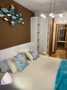 a bedroom with a large white bed with blue pillows at Apartamentos El Escudo Centro in Ribadesella