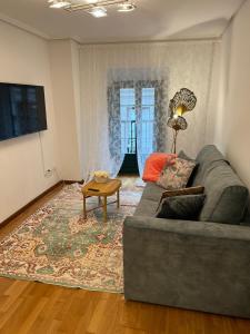 uma sala de estar com um sofá e uma mesa em Apartamentos El Escudo Centro em Ribadesella