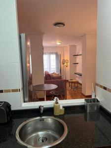 baño con lavabo y sala de estar. en Apartamentos El Escudo Centro, en Ribadesella