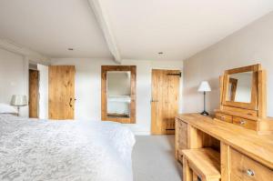 a bedroom with a white bed and wooden cabinets at Primrose Cottage with Log Burner (Dog Friendly) in Settle