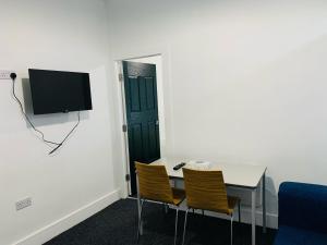 a room with a table and two chairs and a television at Marina Apartments in Bradford