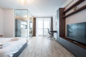 een slaapkamer met een groot bed en een grote flatscreen-tv bij Kondo studio I Roka Residence, Timpuri Noi in Boekarest