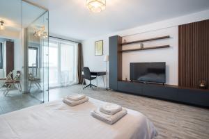 een slaapkamer met een groot bed en 2 handdoeken bij Kondo studio I Roka Residence, Timpuri Noi in Boekarest