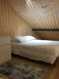 łóżko w pokoju z drewnianą ścianą w obiekcie Studio de 35m2 au centre de Cusset w mieście Cusset