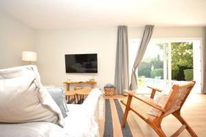 ein Wohnzimmer mit einem weißen Sofa und einem TV in der Unterkunft Apartamento El Castañero in Tacoronte