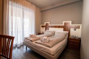 - une chambre avec un grand lit et une fenêtre dans l'établissement Hotel Saligari, à Verceia