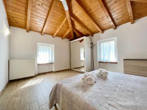 Cette grande chambre comprend un lit et des serviettes. dans l'établissement Villa Carrera, à Malcesine