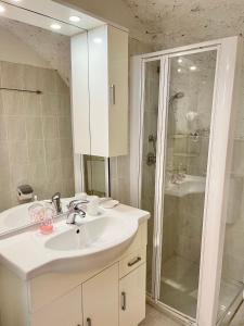 een witte badkamer met een wastafel en een douche bij Villa Carrera in Malcesine
