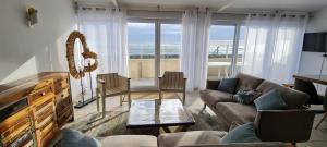 a living room with a view of the ocean at Relais des îles Saint Marcouf in Saint-Marcouf