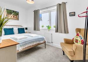 a bedroom with a bed and a chair and a window at Golden Sunset House with free parking by My Getaways in Brighton & Hove