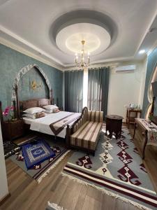 a bedroom with a bed and a couch and a rug at Jannat Minor Boutique Hotel in Urganch