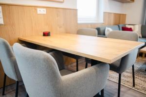 una sala de conferencias con mesa de madera y sillas en Küsten Apartments Tannenhausen, en Aurich