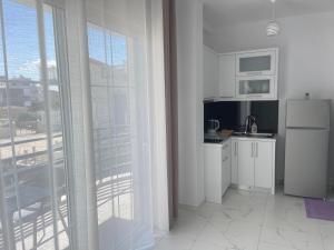 a kitchen with white appliances and a large window at Villa Denis Ksamil in Ksamil