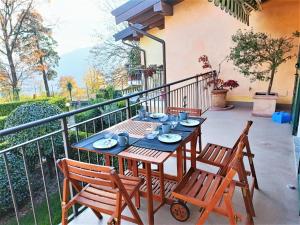 a table and chairs on the balcony of a house at Apartment in Bosco with Scenic Terrace in Montegrino Valtravaglia