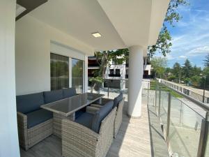 d'une terrasse avec des chaises et une table sur un balcon. dans l'établissement Sunshine Homes Luxury Apartmanok, à Zamárdi