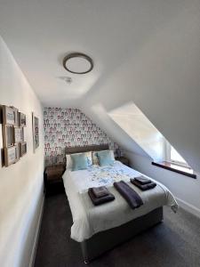 ein Schlafzimmer mit einem Bett mit einer roten Wand in der Unterkunft Islay Frigate Hotel in Tarbert