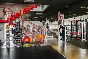 een fitnessruimte met veel apparatuur en een trap bij Blue Orange Resort in Praag