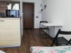 a kitchen with a desk and a table with a microwave at Bridge Apartments Klaipeda in Klaipėda