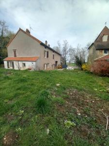 an old house and a yard with a grass field at l'univers, vous et nous in Pouilly-sur-Vingeanne