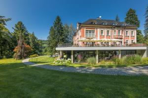 a large house with a balcony on top of it at Wellness & Spa hotel Villa Regenhart in Jeseník